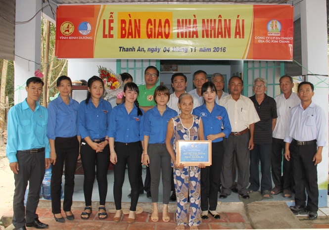 Ông Nguyễn Thuận chụp hình lưu niệm cùng các thành viên trong đoàn và bà Hồ Thị Gái.
