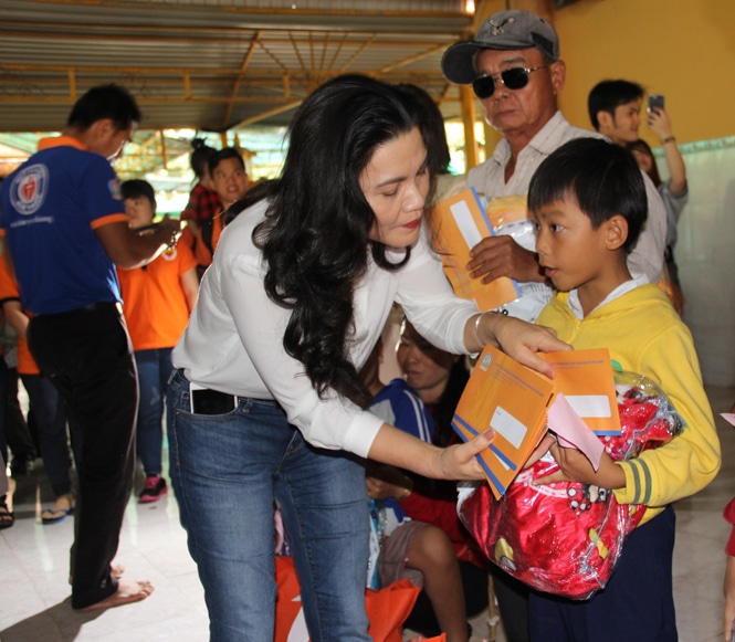 Bà Đặng Thị Kim Oanh, Chủ tịch Hội đồng quản lý Quỹ từ thiện Kim Oanh, kiêm Tổng giám đốc Công ty cổ phần Địa ốc Kim Oanh đang trao quà cho em nhỏ mồ côi tại chùa Vạn Phước.