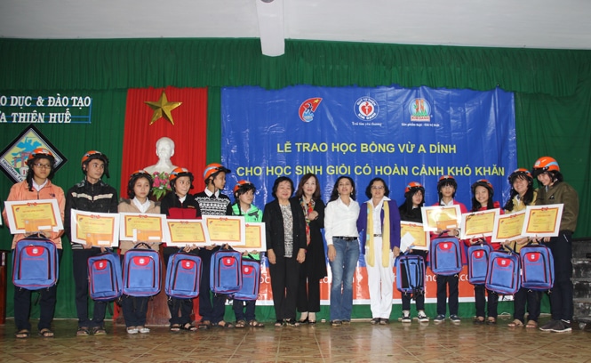 Bà Trương Mỹ Hoa, nguyên Phó chủ tịch nước, Chủ tịch Quỹ học bổng Vừ A Dính và bà Đặng Thị Kim Oanh cùng các thành viên trong đoàn chụp hình lưu niệm với các em học sinh giỏi nhận học bổng. 