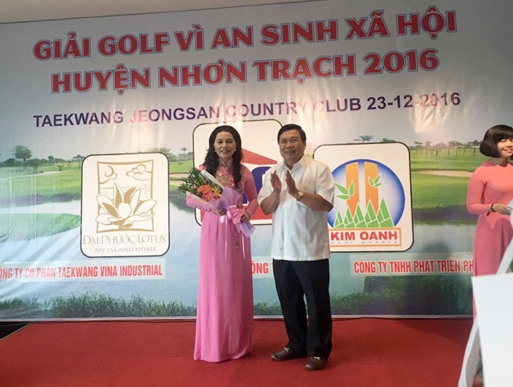 Ông Quách Hữu Đức trao bó hoa tươi thắm cho bà Đặng Thị Kim Oanh thay cho lời cảm ơn những đóng góp của Quỹ từ thiện Kim Oanh dành cho bà con nghèo ở huyện Nhơn Trạch.